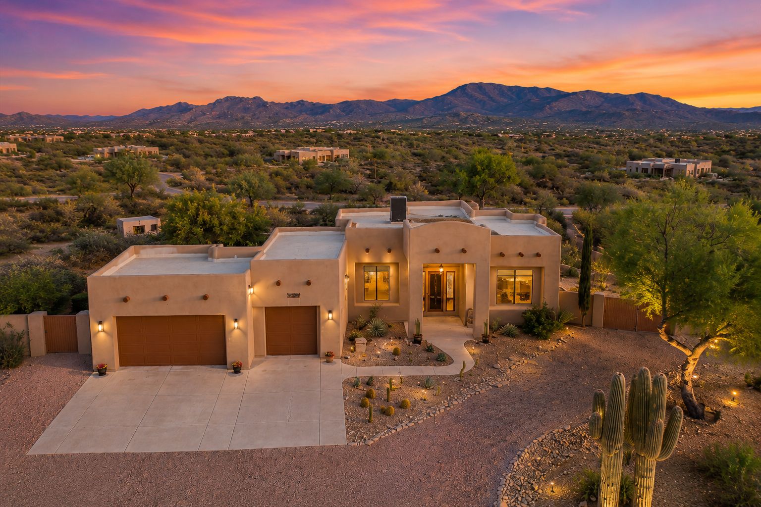 Wide approach to the front of 13919 E Quail Track Road, showing the Santa Fe stucco facade, exposed viga ceiling beams under a covered portico, and the desert landscape that frames the home